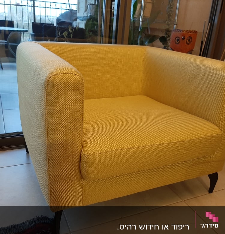 כורסה מרופדת בצבע צהוב עם רגליים כהות